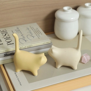 Modern minimalist ceramic cat statues in ginger and cream for elegant home shelf decor
