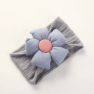 Close-up of grey cable knit baby headband with a soft light blue fabric flower detail