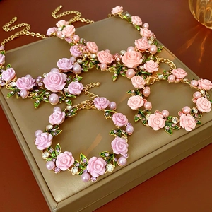 Vue détaillée du collier rose avec perles et cristaux sur un coffret de présentation