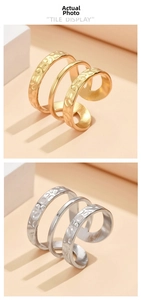 Detail of layered stainless steel rings in gold and silver with hammered texture design