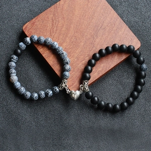 Close-up of matte agate and turquoise beads with heart magnet clasp on wood