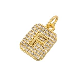 Macro detail of gold-plated square pendant with pavé cubic zirconia and letter F