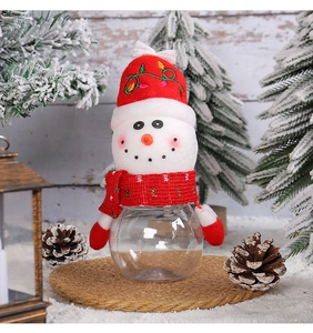 Close-up of a snowman Christmas candy jar with a knitted hat on a festive background