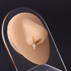 Detail of a gold heart-shaped nose ring with clear zircon crystals on a realistic model