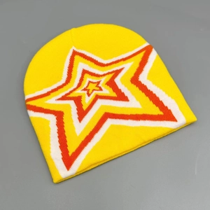 Close-up of yellow knitted beanie showing orange and red star pattern embroidery details