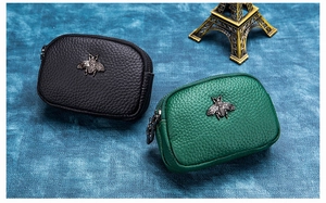 Detail of leather coin purses with litchi texture and vintage metal bee ornaments