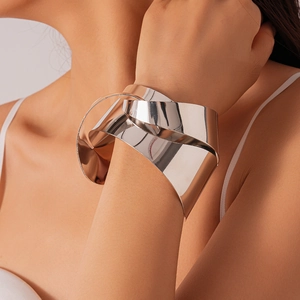 Macro shot of chunky silver knotted metal cuff bracelet on model wrist with high mirror polish