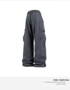 Detalle de pantalones cargo gris oscuro con cintura ajustable y bolsillos laterales de solapa