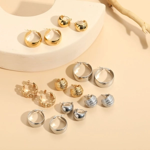 Detailed macro view of assorted gold and silver geometric titanium steel earrings on stands