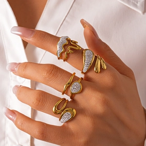 Detail of 18K gold stainless steel rings with zircons on a model in white shirt
