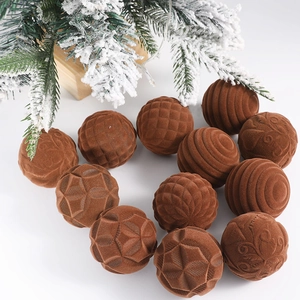 Detailed view of brown flocked Christmas balls with various textures under snowy pine branches