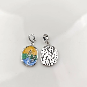Detail of oil painting style enamel rose pendant and silver wave charm with metal ring hooks