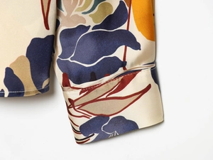 Close-up of printed satin shirt cuff showing intricate floral texture and fine stitching