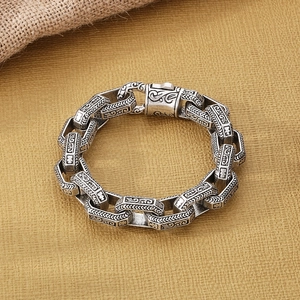 Close-up of retro stainless steel chain bracelet with ethnic carvings and buckle clasp