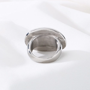Vintage bohemian oval stainless steel ring on elegant white satin background fabric