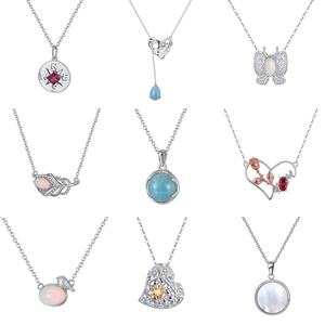 Collection of nine bohemian silver pendants featuring opal, compass, and heart shapes