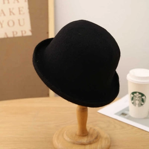 Detail of a black wool felt dome hat on a wooden stand with a classic rolled brim design