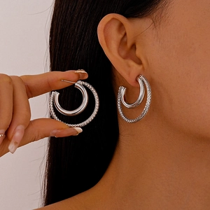 Silver double-layer C-shaped hoop earrings with textured outer ring and polished inner band