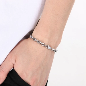 Detailed shot of a silver stainless steel link bracelet on a model's wrist with lobster clasp