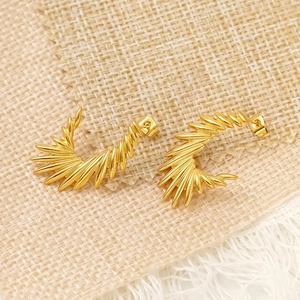 Boucles d'oreilles ailes d'ange dorées avec design radial sur tissu texturé