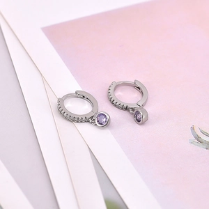 Detail of silver hoop earrings with white micro-diamonds and round purple zircon stones