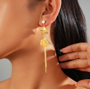 Vue détaillée de boucles d'oreilles éventail plaquées or 18 carats avec zircons et franges