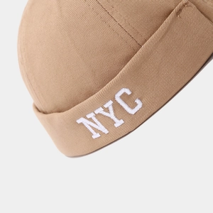 Macro detail of NYC embroidery and khaki twill fabric on a vintage brimless docker cap