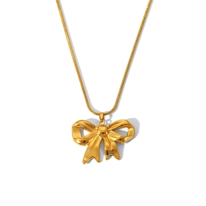 Detailed view of a gold-tone snake chain necklace with a 3D bow pendant on white background