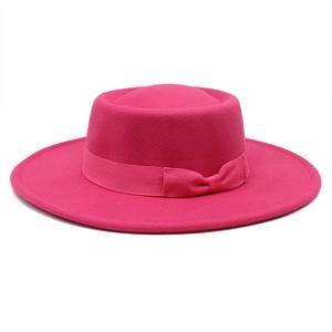 Detail of rose red wool felt flat top hat featuring a stylish matching bow ribbon tie