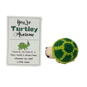 Handmade crochet positive green turtle doll with motivational gift card set on white background