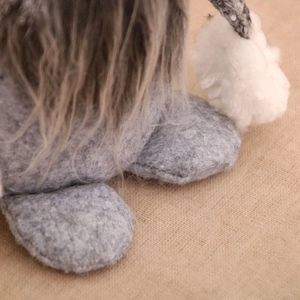 Detailed close-up of grey felt feet and white pom-pom on Christmas gnome decoration