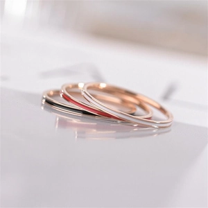 Close-up of three-piece stackable titanium steel rings with rose gold and colorful enamel