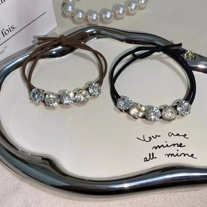 Sparkling crystal elastic hair bands in black and brown on an elegant jewelry tray