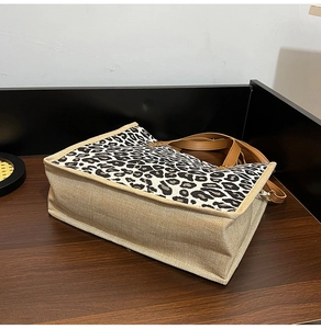 Detail view of stylish leopard print linen tote bag with brown faux leather handles