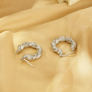 Close-up of silver twisted hoop earrings with polished stainless steel texture