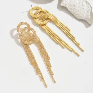 Detailed view of long rhinestone tassel earrings in silver and gold plated finishes