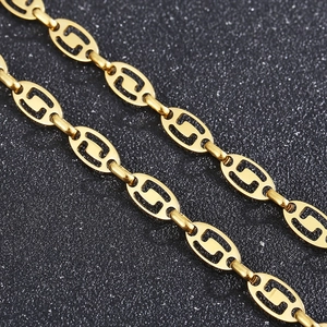 Detailed close-up of golden stainless steel interlocking oval chain links on black background