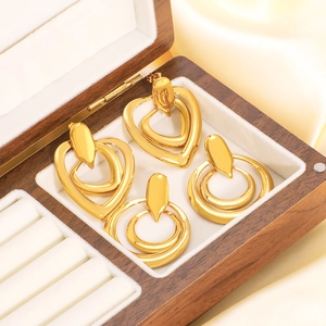 Gold-plated stainless steel layered heart and circle stud earrings set in a wooden box