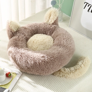 Plush cat shaped pet bed with cute ears and tail on a cozy white knitted carpet