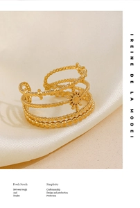 Détail macro de la bague étoile multicouche plaquée or 18K sur tissu satiné