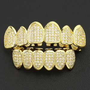 Macro view of gold plated hiphop grillz set with micro paved zircon on black leather