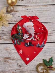 Detail of red Christmas pet bandana with Santa Claus print on vintage white wood floor