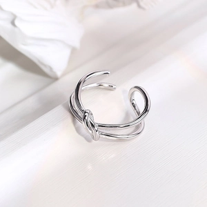 Macro shot of silver knotted double-layer open ring featuring polished stainless steel finish