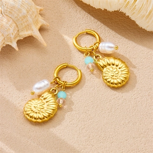 Gold conch shell earrings with colorful beads and pearls on a beach sand background