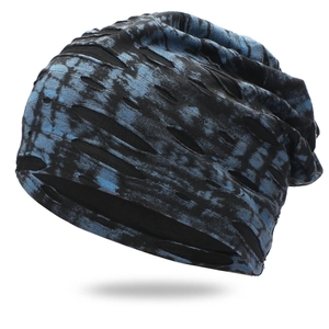 Detail showing tie-dye pattern and distressed ripped holes on the knit beanie fabric