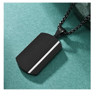 Detail of black military tag pendant with textured surface and silver stripe accent