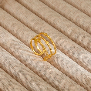 Detail of gold spiral ring with beaded texture and moon star accents on a display