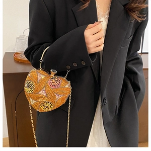 Detail of heart-shaped evening bag with sequin floral embroidery and crystal clasp