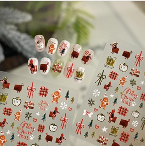 Detail of Christmas nail stickers featuring gingerbread men and gold dachshund motifs
