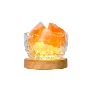 Himalayan crystal salt lamp with orange rocks in engraved glass bowl on wood base